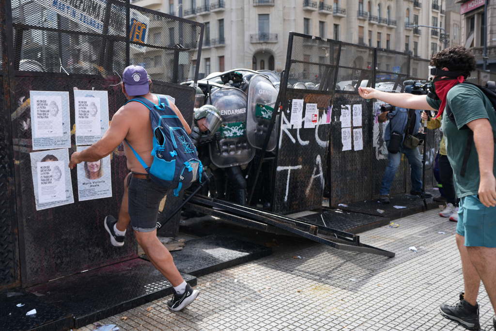 Protesters push against a police barrier during a march by trade unions and opposition groups against a labor reform bill proposed by President Javier Milei's government outside Congress in Buenos Aires, Argentina, Wednesday, Feb. 11, 2026. (AP Photo/Gustavo Garello)