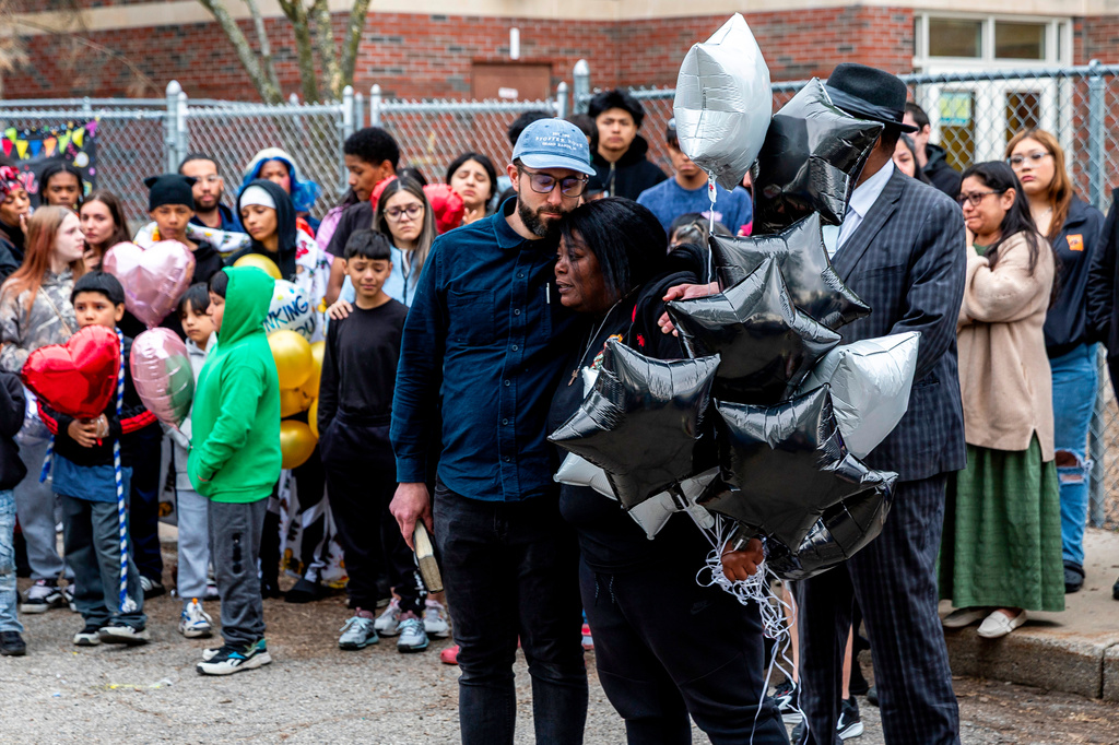 Berean Baptist Church senior pastor David Geroux embraces mother Mildred Griffin as about people gather for a balloon-release vigil to honor Savannah Rubio, 39, and Jeremiah Cuevas-Griffin, 15, who were shot and killed the night before amid a dispute over a soccer game at Southwest Elementary School in Grand Rapids, Mich. on Wednesday, May 6, 2026. (Isaac Ritchey/The Grand Rapids Press via AP)