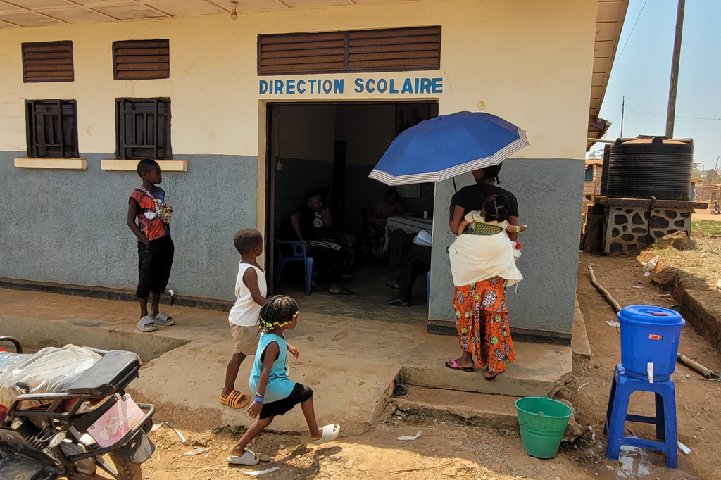A parent who came for her child's school resumption stands outside the school in Ituri province, eastern Congo, Thursday, Aug. 27, 2026. (AP Photo/Constant Same Bagalwa)