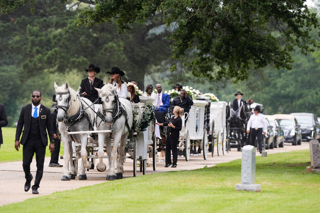 Caissons carry the caskets of eight children who were killed during a mass shooting last month, Saturday, May 9, 2026, at Forest Park Cemetery West in Shreveport, La. (AP Photo/Gerald Herbert)