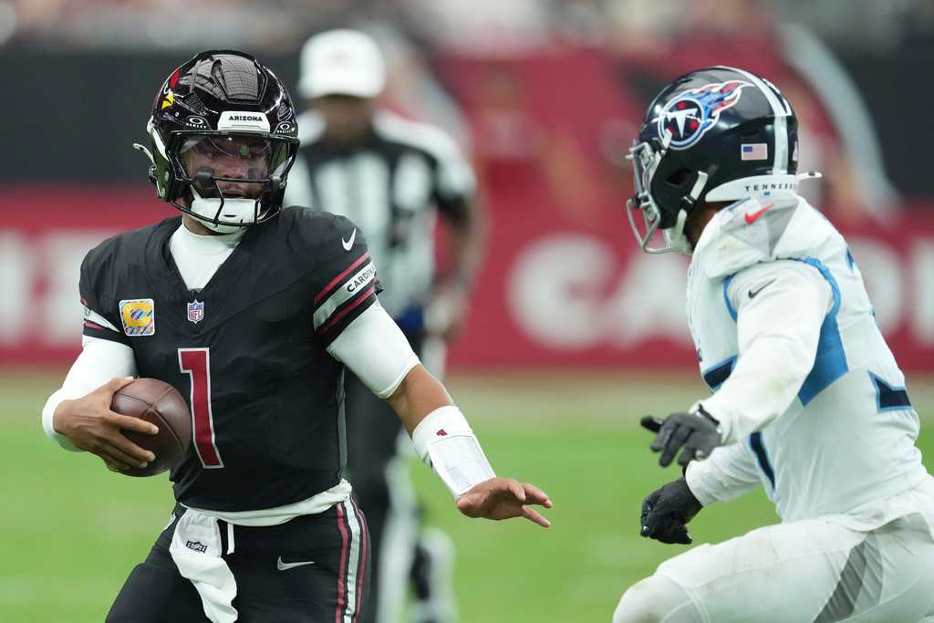 Arizona Cardinals quarterback Kyler Murray (1) runs the ball against the Tennessee Titans safety Amani Hooker, right, during the second half of an NFL football game Sunday, Oct. 5, 2025, in Glendale, Ariz. (AP Photo/Ross D. Franklin)