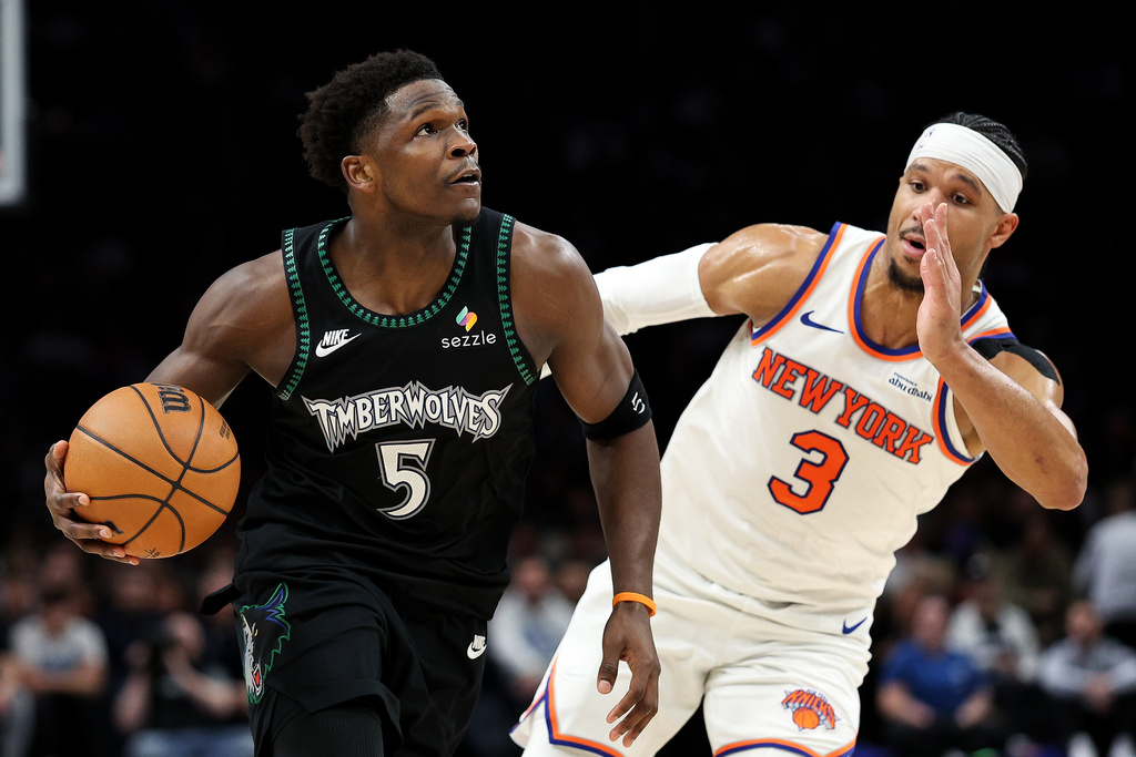 Minnesota Timberwolves guard Anthony Edwards, left, works around New York Knicks guard Josh Hart (3) during the first half of an NBA basketball game Tuesday, Dec. 23, 2025, in Minneapolis. (AP Photo/Matt Krohn)