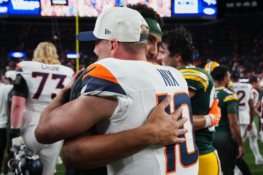 Denver Broncos quarterback Bo Nix (10) and Green Bay Packers quarterback Jordan Love embrace after an NFL preseason football game Friday, Aug. 21, 2026, in Denver. (AP Photo/Jack Dempsey)
