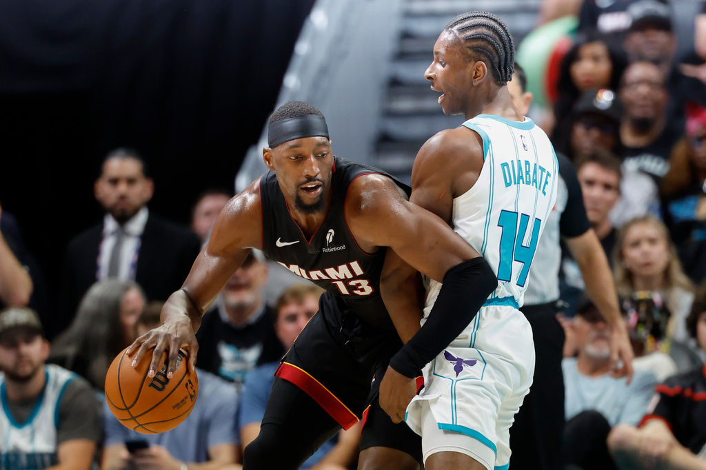 Miami Heat center Bam Adebayo, left, drives against Charlotte Hornets forward Moussa Diabate during the first half of an NBA play-in tournament basketball game in Charlotte, N.C., Tuesday, April 14, 2026. (AP Photo/Nell Redmond)