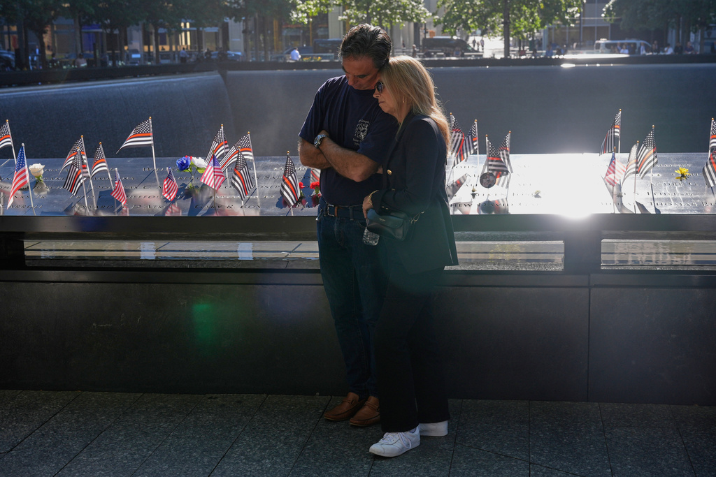 People bow their heads during a moment of silence during a ceremony to mark the 24th anniversary of the 9/11 attacks, Thursday, Sept. 11, 2025, in New York. (AP Photo/Seth Wenig)