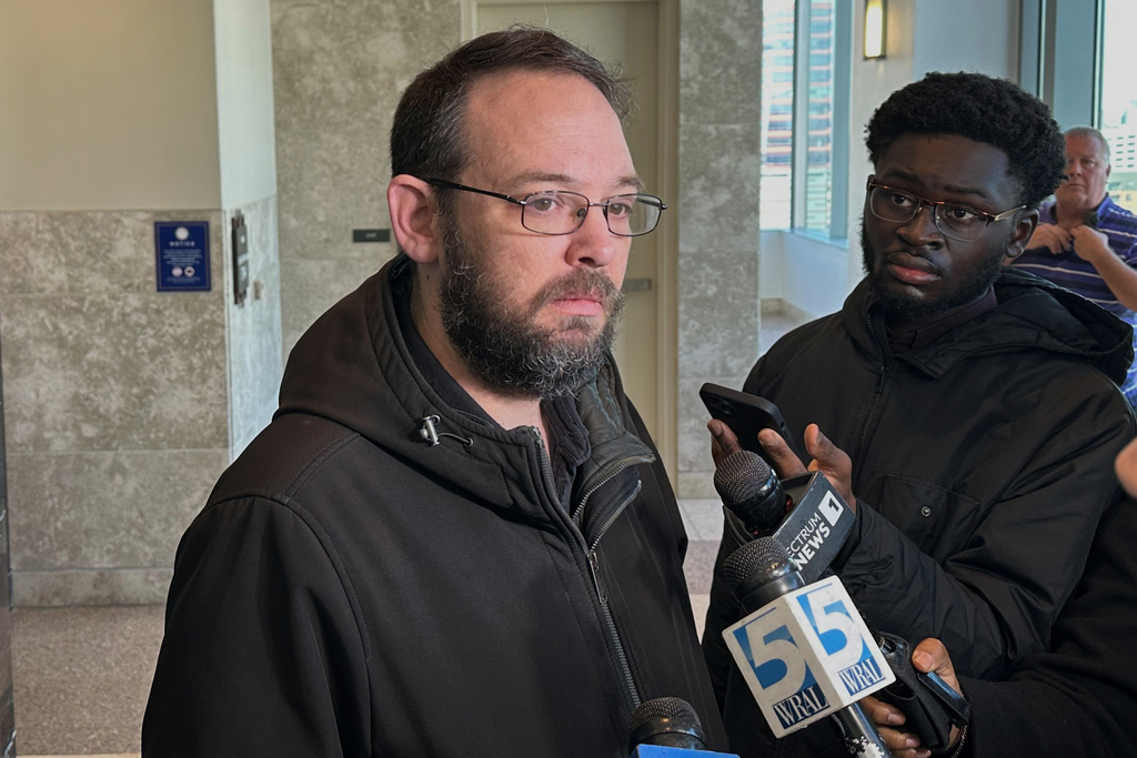 Rob Steele, center, the fiancé of 2022 mass shooting victim Mary Marshall, speaks to reporters at the Wake County Justice Center after a judge sentenced shooting defendant Austin Thompson to life in prison without the possibility of parole on Friday, Feb. 13, 2026, in Raleigh, N.C. (AP Photo/Gary D. Robertson)