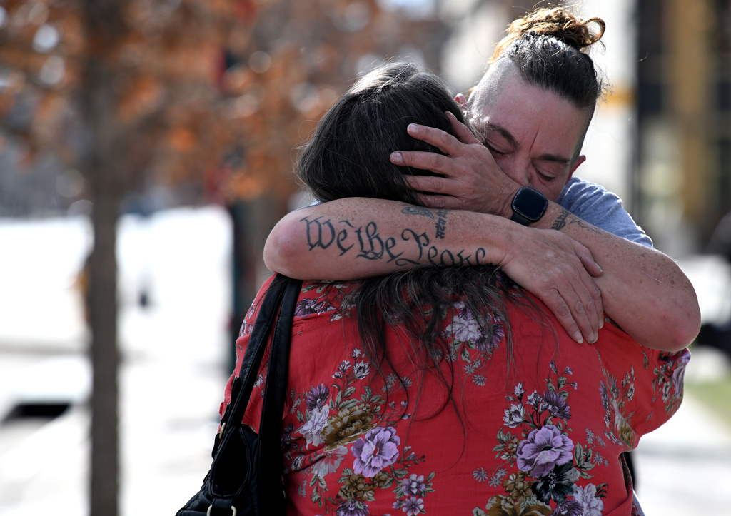 Crystina Page, back, hugs Angelika Stedman outside the El Paso County Courthouse in Colorado Springs, Colo., Monday, Dec. 22, 2025, before speaking to the press ahead of the court hearing for Return to Nature funeral home owners Jon and Carie Hallford. (Christian Murdock/The Gazette via AP)