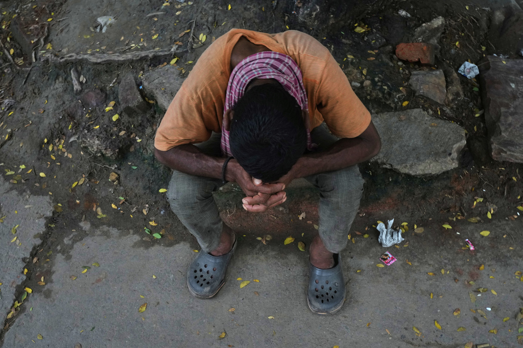A man takes a break from working on the banks of the swollen river Yamuna in New Delhi, India, Tuesday, Sept. 2, 2025. (AP Photo/Manish Swarup)