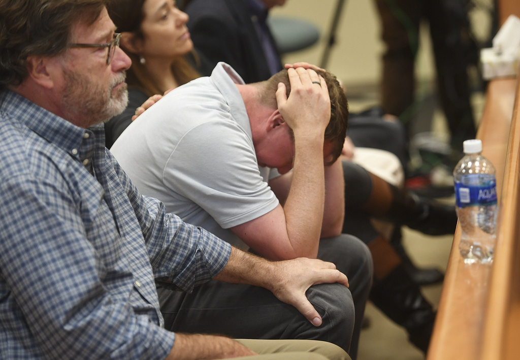 FILE - Plaintiff Robbie Parker drops his head in his hands and fellow plaintiffs William Sherlach, left, and Francine Wheeler lend emotional support as the jury verdict awards are read in the Alex Jones defamation trial at Superior Court, Oct. 12, 2022, in Waterbury, Conn. (Brian A. Pounds/Hearst Connecticut Media via AP, Pool)
