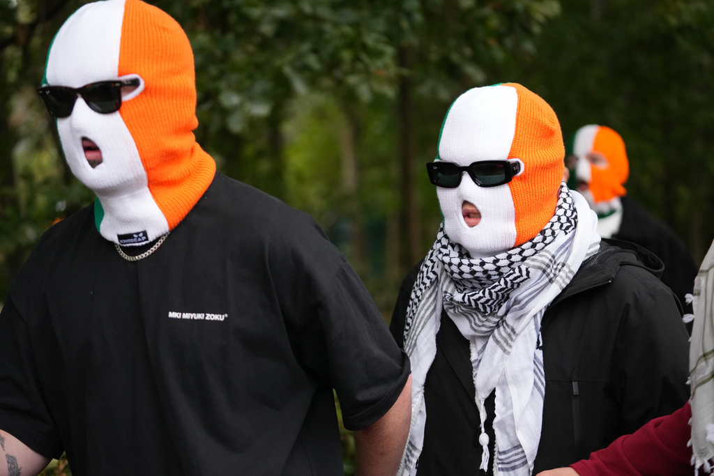 A person believed to be Liam Óg Ó hAnnaidh, aka Mo Chara, right, a member of the Irish language band Kneecap, arrives at Woolwich Crown Court in London London, Friday, Sept. 26, 2025, where he is charged with a terrorism offence relating to displaying a flag in support of Hezbollah during a performance with the band in November 2024. (AP Photo/Joanna Chan)