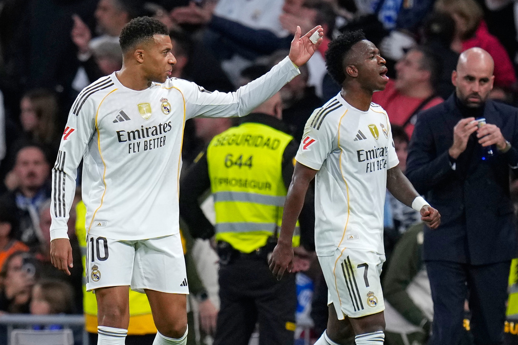 Real Madrid's Kylian Mbappe, left, and Vinicius Junior react during the Spanish La Liga soccer match between Real Madrid and Celta Vigo in Madrid, Spain, Sunday, Dec. 7, 2025. (AP Photo/Manu Fernandez)
