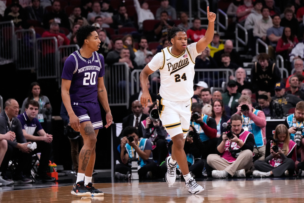 Purdue forward Raleigh Burgess, right, points after he scored a 3-point basket as Northwestern guard Justin Mullins looks on during the first half of an NCAA college basketball game in the third round of the Big 10 Conference tournament, Thursday, March 12, 2026, in Chicago. (AP Photo/Nam Y. Huh)