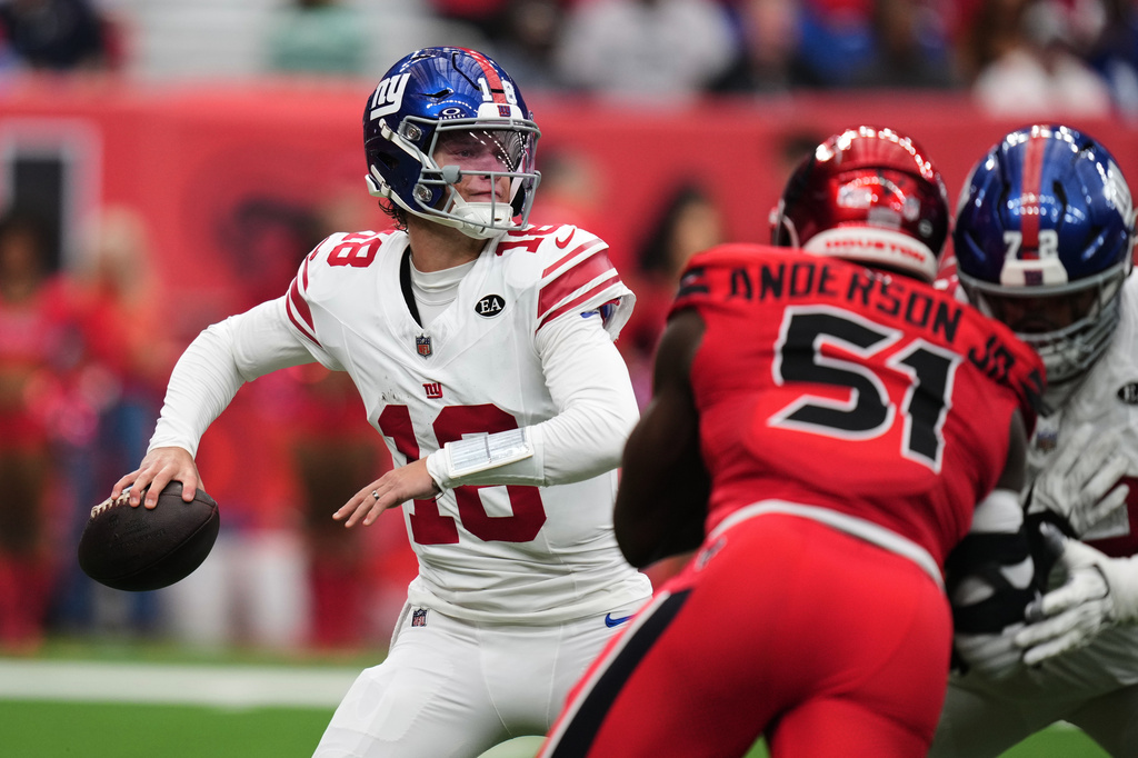 New York Giants quarterback J.J. McCarthy (18) throws a pass under pressure by Houston Texans defensive end Will Anderson Jr. (51) during the first half of an NFL football game in Houston, Sunday, Oct. 25, 2026. (AP Photo/Eric Smith)
