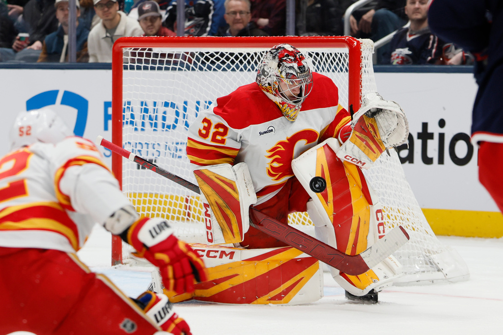 Calgary Flames' Dustin Wolf makes a save against the Columbus Blue Jackets during the first period of an NHL hockey game, Tuesday, Jan. 13, 2026, in Columbus, Ohio. (AP Photo/Jay LaPrete)
