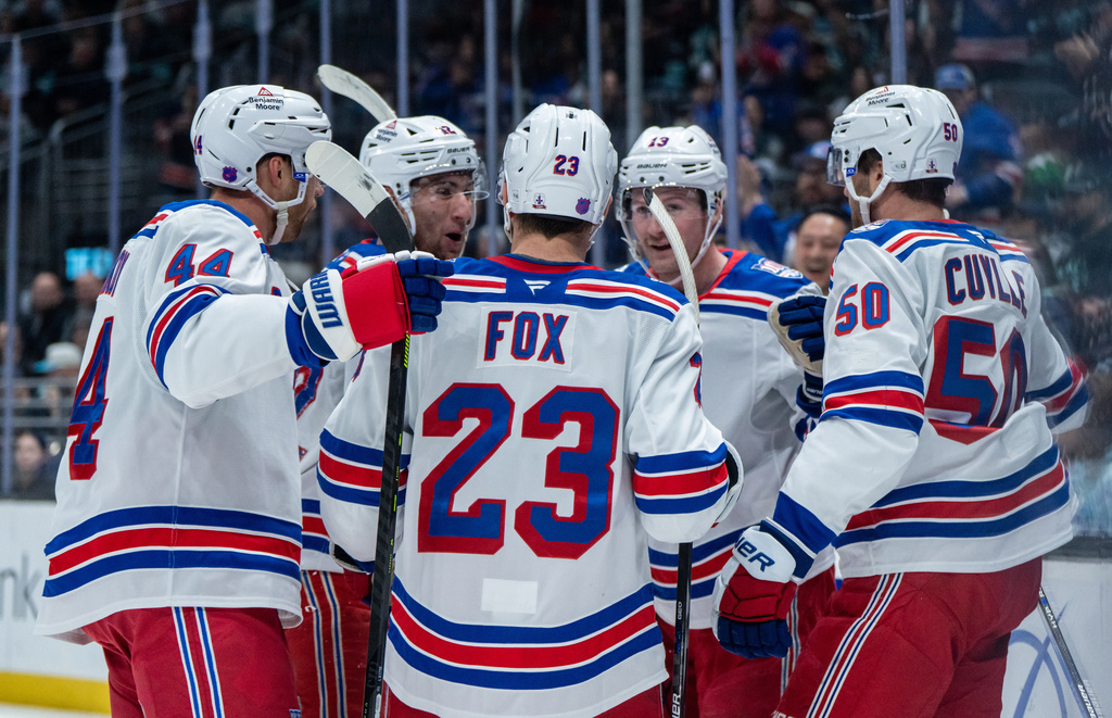 New York Rangers defenseman Vladislav Gavrikov, left, forward Noah Laba, second from left, defenseman Adam Fox (23), forward Alexis Lafreniere (13) and forward Will Cuylle celebrate a goal during the first period of an NHL hockey game against the Seattle Kraken, Saturday, Nov. 1, 2025, in Seattle. (AP Photo/Stephen Brashear)