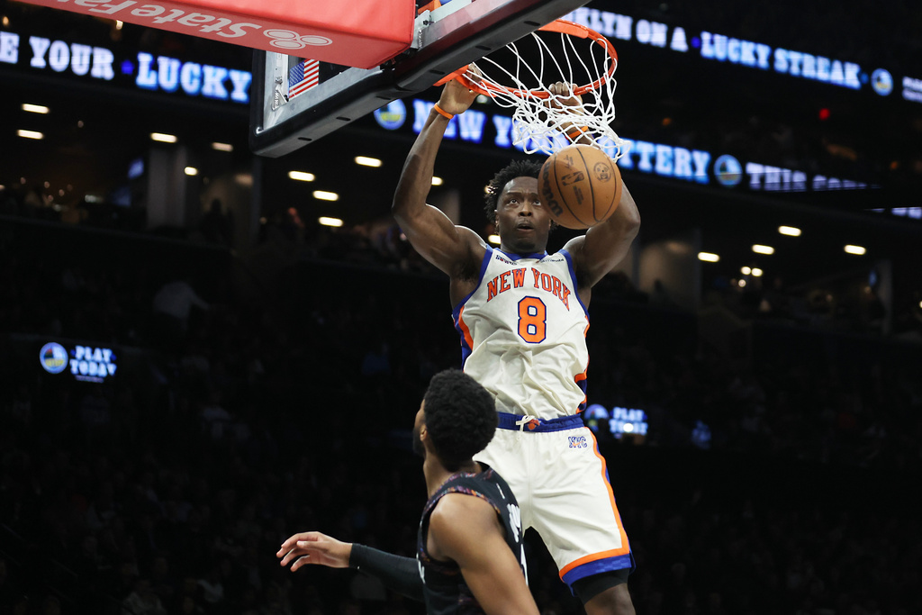 New York Knicks forward Og Anunoby (8) dunks over Brooklyn Nets forward Chaney Johnson, bottom, during the second half of an NBA basketball game, Friday, March 20, 2026, in New York. (AP Photo/Heather Khalifa)