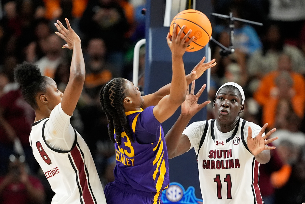 LSU guard Milaysia Fulwiley drives to the basket between South Carolina forward Joyce Edwards and center Madina Okot (11) during the second half of an NCAA college basketball game in the semifinals of the Southeastern Conference tournament, Saturday, March 7, 2026, in Greenville, S.C. (AP Photo/Chris Carlson)