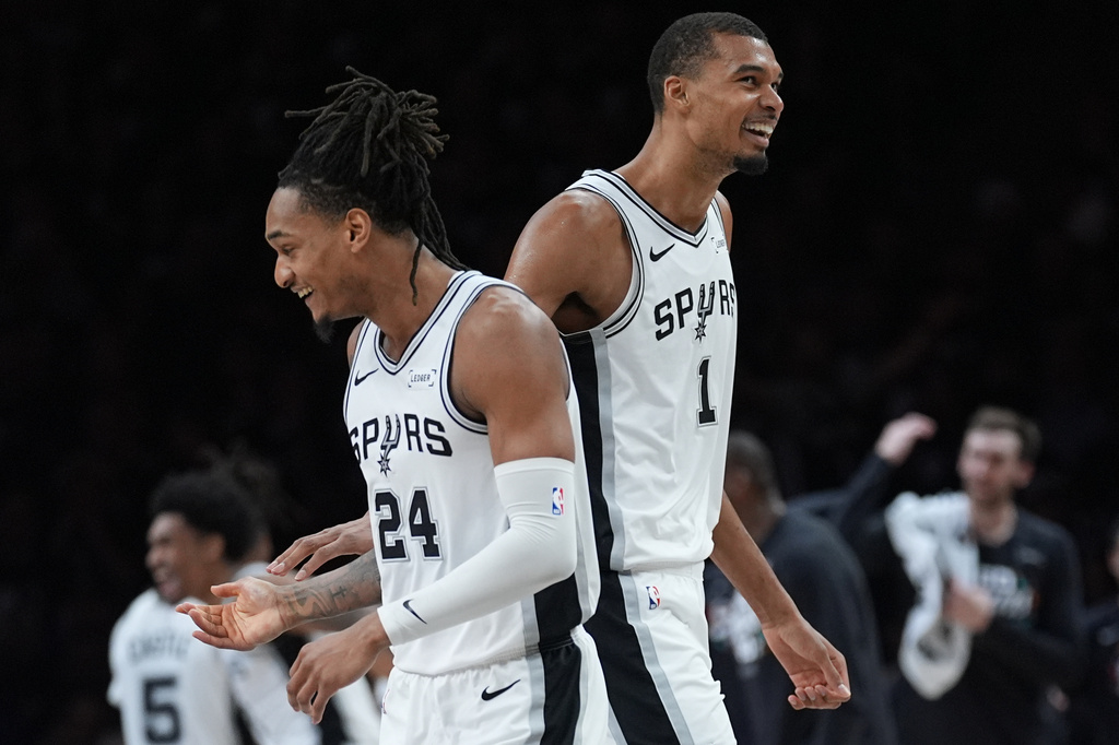 San Antonio Spurs guard Devin Vassell (24) and forward Victor Wembanyama (1) celebrate a score against the Minnesota Timberwolves during the first half of Game 6 of an NBA basketball second-round playoffs series in Minneapolis, Friday, May 15, 2026. (AP Photo/Abbie Parr)