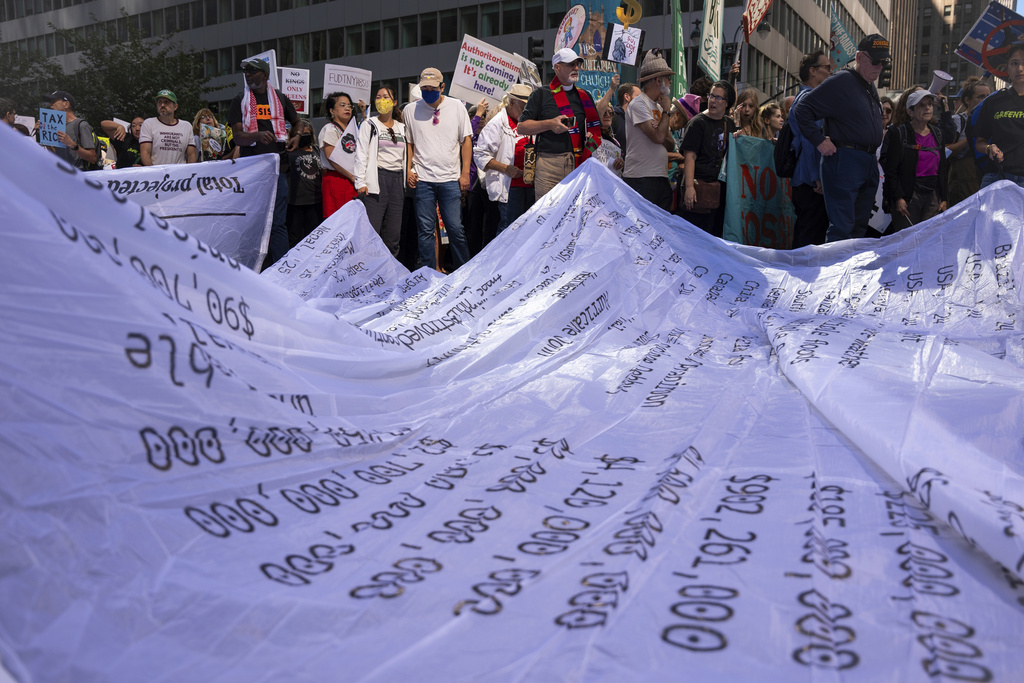 People set up a "Climate Polluters Bill" the length of an Olympic swimming pool (50 meters long) through Manhattan at the "Make Billionaires Pay" climate protest, Saturday, Sept. 20, 2025, in New York. The bill was created by Greenpeace and lists the costs of hundreds of climate-related natural disasters. (AP Photo/Angelina Katsanis)