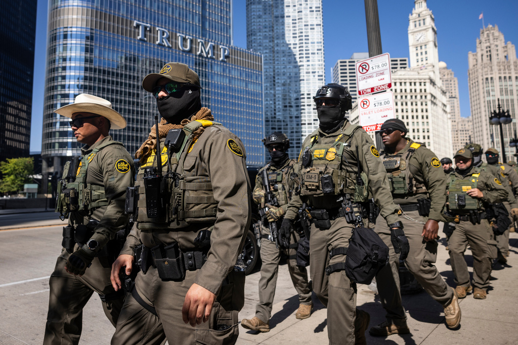 Federal agents from U.S. Immigration and Customs Enforcement and U.S. Customs and Border Protection walk along West Wacker Drive in the Loop, Sunday, Sept. 28, 2025, in Chicago. (Ashlee Rezin/Chicago Sun-Times via AP)