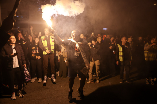 A protestor holds a flare as he welcomes students marching to Novi Sad for a rally on Nov. 1 marking the first anniversary of a train station disaster that killed 16 people, in Indjija, Serbia, Thursday, Oct. 30, 2025. (AP Photo/Armin Durgut) A protestor holds a flare as he welcomes students marching to Novi Sad for a rally on Nov. 1 marking the first anniversary of a train station disaster that killed 16 people, in Indjija, Serbia, Thursday, Oct. 30, 2025. (AP Photo/Armin Durgut)