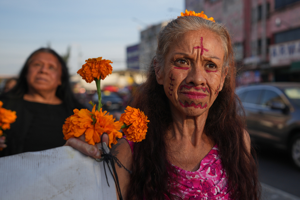 Women take part in a march honoring deceased sex workers ahead of the Day of the Dead celebrations in Mexico City, Friday, Oct. 31, 2025. (AP Photo/Claudia Rosel)