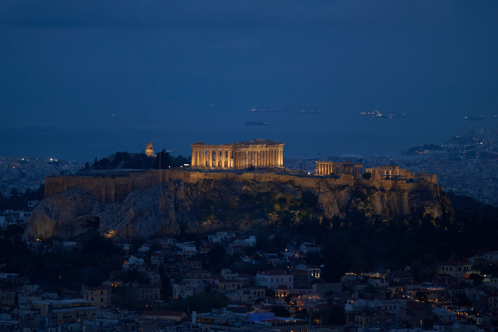 A general view of Athens with the illuminated Acropolis hill and the Saronic Gulf in the background on Wednesday, Oct. 21, 2025. (AP Photo/Petros Giannakouris)