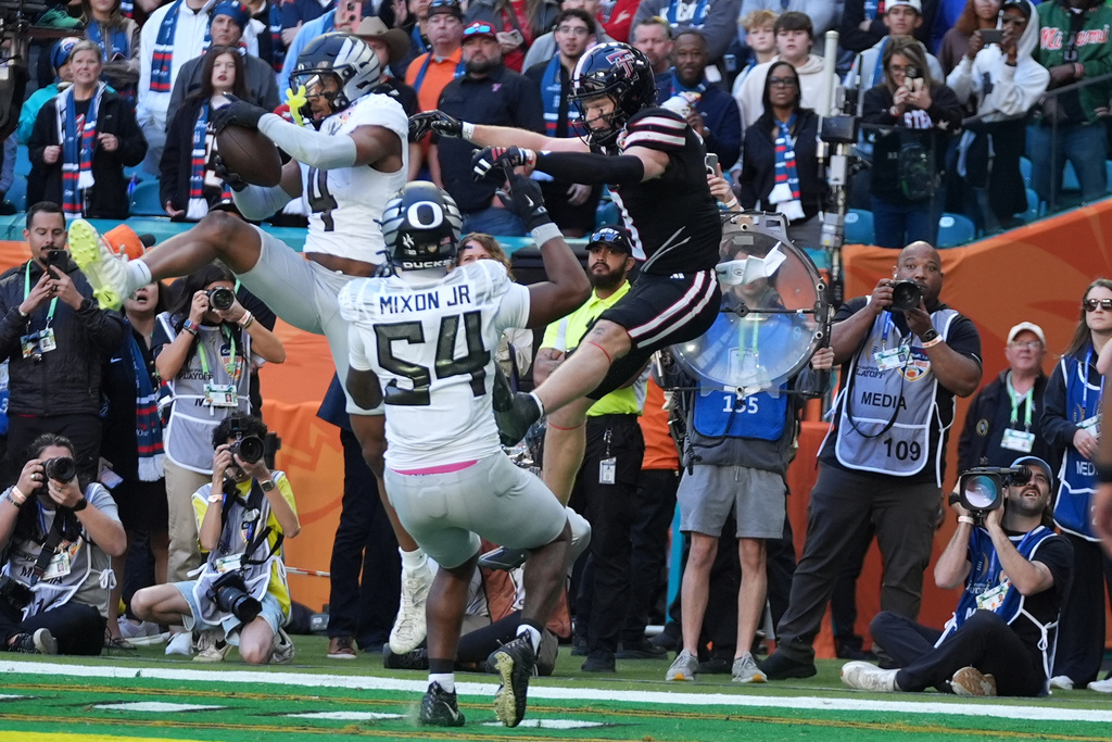 Oregon defensive back Brandon Finney (4) intercepts a pass intended for Texas Tech wide receiver Coy Eakin, right, during the second half of the Orange Bowl College Football Playoff quarterfinal game, Thursday, Jan. 1, 2026, in Miami Gardens, Fla. (AP Photo/Lynne Sladky)