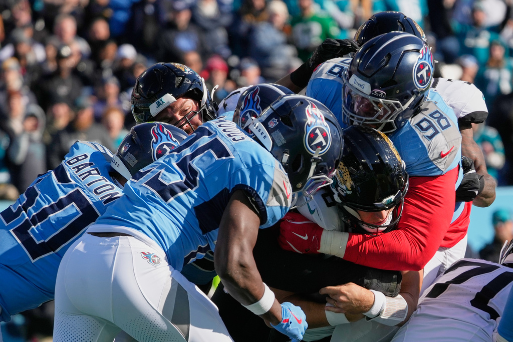 Jacksonville Jaguars quarterback Trevor Lawrence, center, pushes his way past the Tennessee Titans defense for a 2-point conversion during the first half of an NFL football game Sunday, Nov. 30, 2025, in Nashville, Tenn. (AP Photo/George Walker IV)