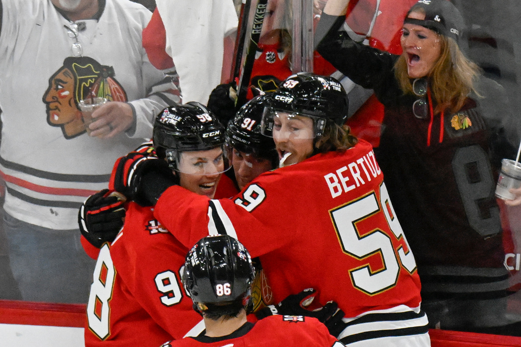 Chicago Blackhawks' Connor Bedard (98), left, celebrates his goal with Frank Nazar, center, and Tyler Bertuzzi (59) during the second period of an NHL hockey game against the Montreal Canadiens, Saturday, Oct. 11, 2025, in Chicago. (AP Photo/Matt Marton)