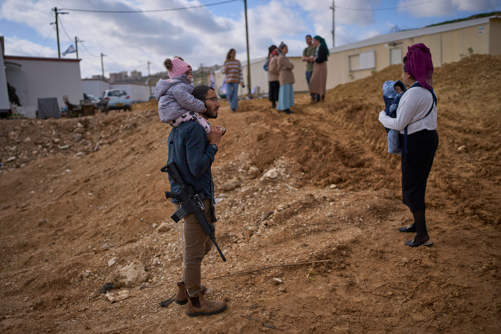 Settlers attend the inauguration ceremony for a newly-legalized Jewish settlement, Yatziv, adjacent to the Palestinian town of Beit Sahour, in the West Bank, Monday, Jan. 19, 2026. (AP Photo/Ohad Zwigenberg)
