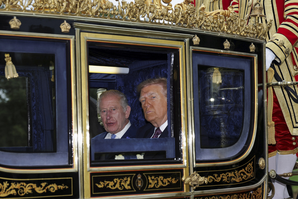 Britain's King Charles III and President Donald Trump sit in a carriage during a procession through Windsor Castle, in Windsor, England, Wednesday, Sept. 17, 2025. (Toby Melville/Pool Photo via AP)