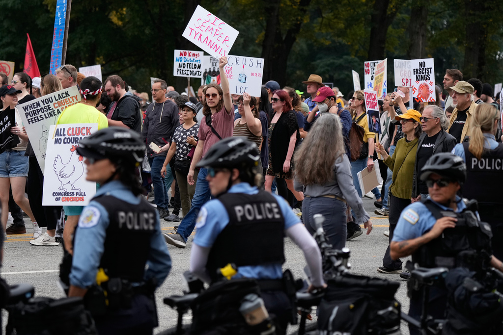 Chicago police watch as people take part in a "No Kings" protest Saturday, Oct. 18, 2025, in Chicago. (AP Photo/Nam Y. Huh)