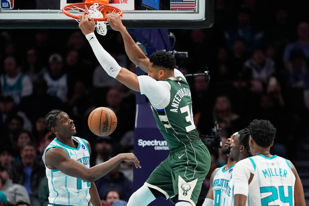 Milwaukee Bucks forward Giannis Antetokounmpo dunks over Charlotte Hornets forward Moussa Diabate during the first half of an NBA basketball game, Monday, Dec. 29, 2025, in Charlotte, N.C. (AP Photo/Chris Carlson)