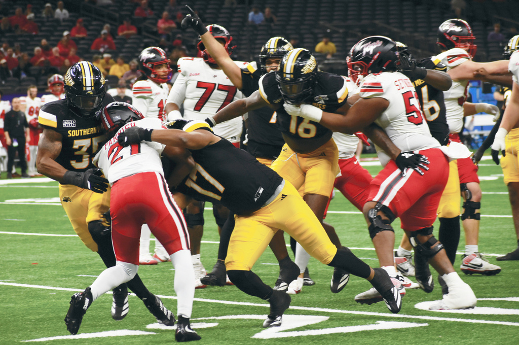 Western Kentucky Running Back Marvis Parrish (21) is stopped defensively by Southern Miss defenders Chris Jones (35) and Michael Montgomery (17) during the first half of an NCAA college football game at the New Orleans Bowl Tuesday, Dec. 23, 2025 in New Orleans, La. (Aimee Cronan/The Gazebo Gazette via AP)