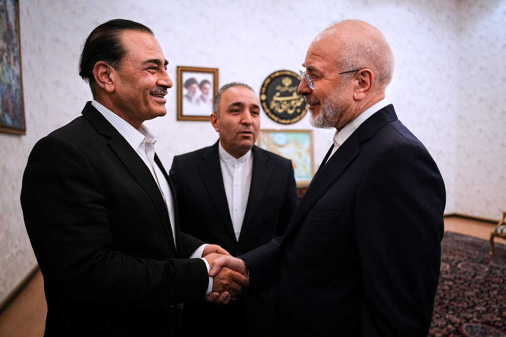 In this photo released by Islamic Consultative Assembly News Agency, ICANA, Iran's Parliament Speaker and top negotiator Mohammad Bagher Qalibaf, right, shakes hands with Pakistan's Army Chief Field Marshal Gen. Asim Munir during their meeting in Tehran, Iran, Monday, Aug. 24, 2026. (Mahmoud Hosseini/ICANA via AP)