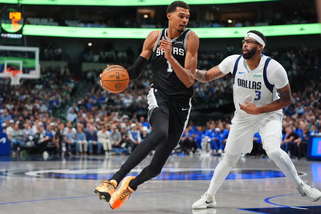 San Antonio Spurs forward Victor Wembanyama (1) drives against Dallas Mavericks forward Anthony Davis (3) during the first half of an NBA basketball game in Dallas, Wednesday, Oct. 22, 2025. (AP Photo/LM Otero)