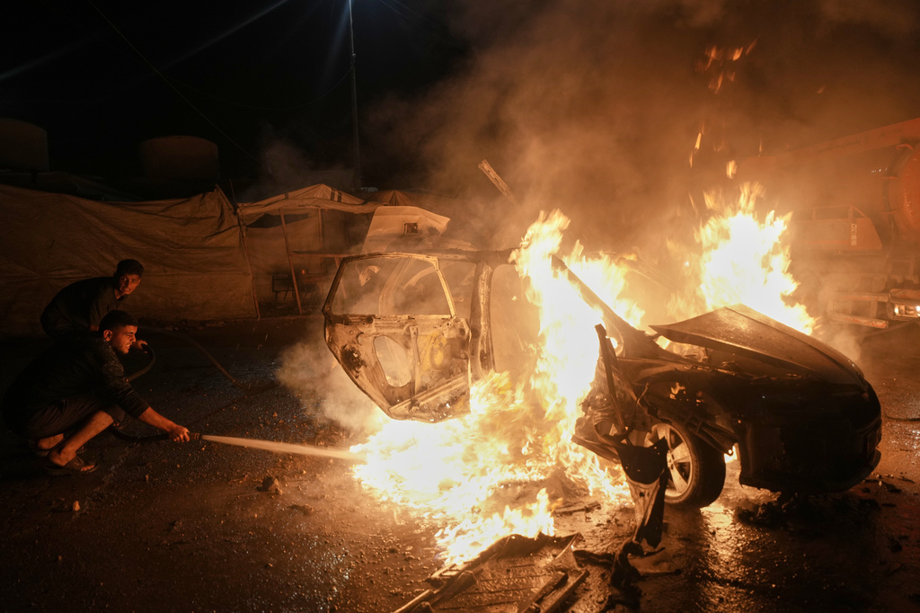 Palestinians work to extinguish a fire in a vehicle that was hit by an Israeli strike in the Rimal neighborhood of Gaza City, Friday, May 15, 2026. (AP Photo/Jehad Alshrafi)