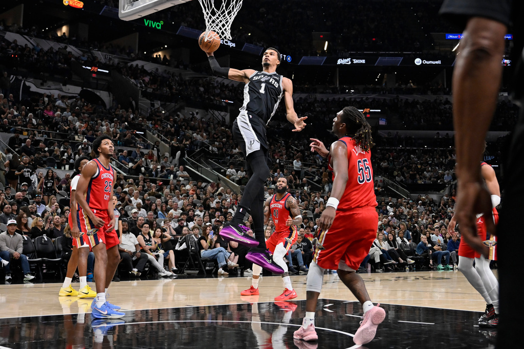 San Antonio Spurs center Victor Wembanyama (1) goes up to dunk during the first half of an NBA basketball game against the New Orleans Pelicans, Saturday, Nov. 8, 2025, in San Antonio. (AP Photo/Darren Abate)
