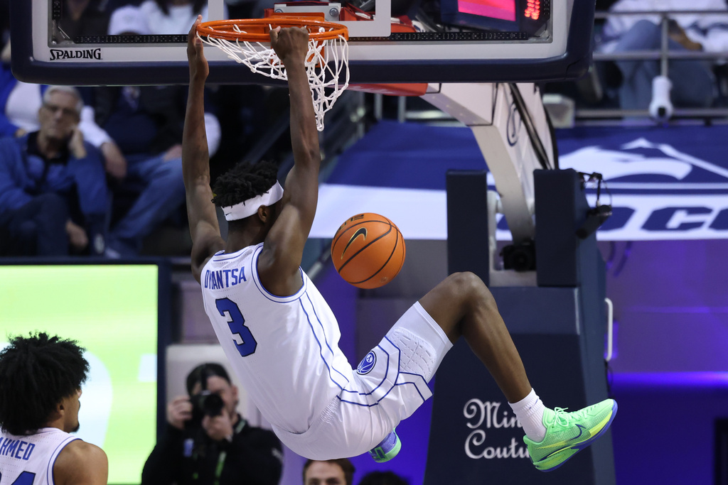 BYU forward AJ Dybantsa (3) hangs from the rim after dunking against Arizona during the second half of an NCAA college basketball game, Monday, Jan. 26, 2026, in Provo, Utah. (AP Photo/Rob Gray)