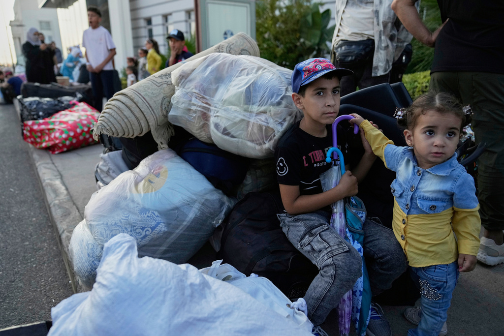 FILE - Syrian children sit next to their belongings at a gathering point, as they wait to be checked by Lebanese security forces before boarding buses to return home to Syria, in Beirut, Lebanon, Thursday, Sept. 11, 2025. (AP Photo/Hussein Malla, File)