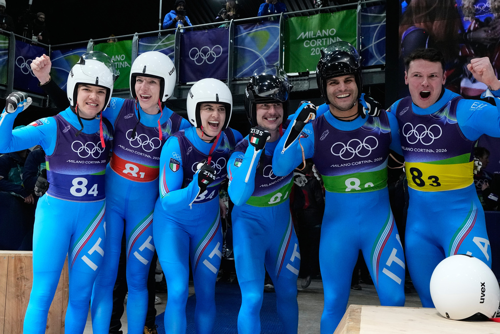 Italy's Verena Hofer, Simon Kainzwaldner, Marion Oberhofer, Andrea Voetter, Emanuel Rieder and Dominik Fischnaller celebrate during the luge relay competition at the 2026 Winter Olympics, in Cortina d'Ampezzo, Italy, Thursday, Feb. 12, 2026. (AP Photo/Alessandra Tarantino)