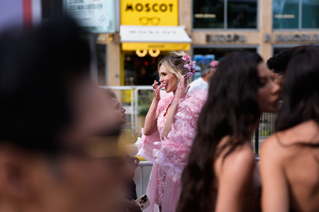 A festivalgoer gets ready along the street before walking along the red carpet at the 79th international film festival, Cannes, southern France, Monday, May 18, 2026. (AP Photo/John Locher)