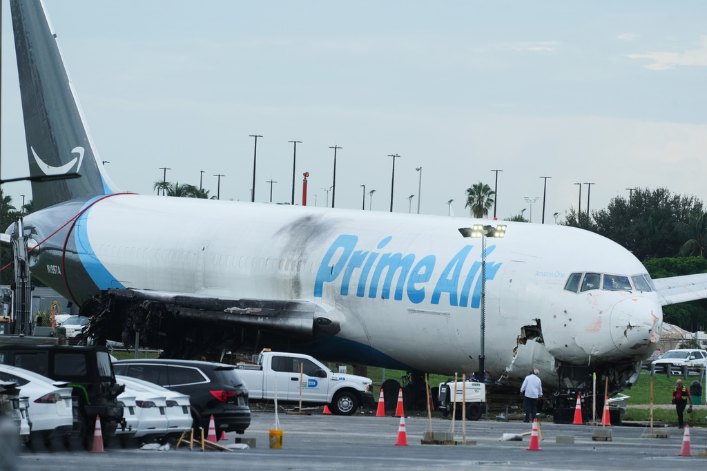 Workers inspect an Amazon cargo plane that overshot a runway four days ago at Miami International Airport, Thursday, Sept. 10, 2026, in Miami. (AP Photo/Marta Lavandier)