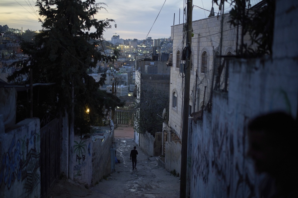 Nasser al-Heimouni, 38, walks down an alley near the spot where his 12-year-old son, Ayman al-Heimouni, was shot by Israeli fire in the West Bank city of Hebron, March 26, 2025. (AP Photo/Leo Correa)