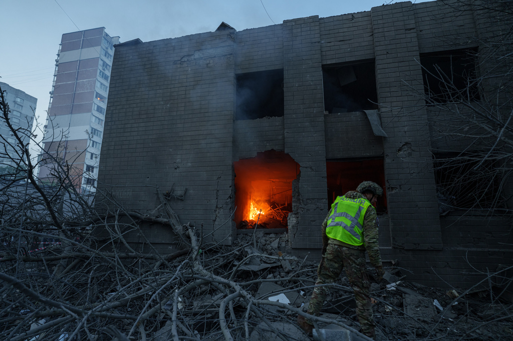 A policeman look at a building damaged after a Russian strike on residential neighbourhood in Kyiv, Ukraine, on Thursday, May 14, 2026. (AP Photo/Evgeniy Maloletka)
