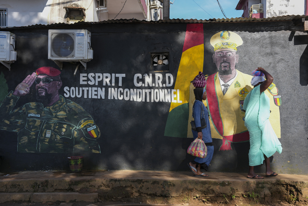People walk past a mural showing Guinea's interim president, Col. Mamadi Doumbouya, ahead of the constitutional referendum in Conakry, Guinea, Wednesday, Sept. 17, 2025. (AP Photo/Misper Apawu)