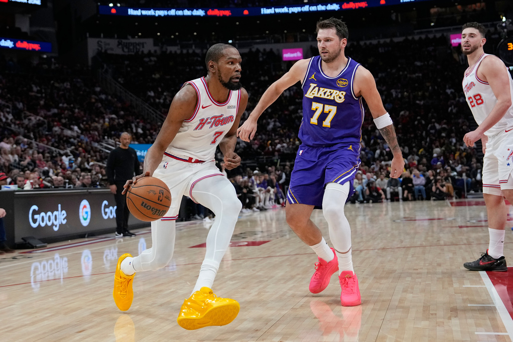 Houston Rockets' Kevin Durant (7) drives toward the basket as Los Angeles Lakers' Luka Doncic (77) defends during the first half of an NBA basketball game Wednesday, March 18, 2026, in Houston. (AP Photo/David J. Phillip)