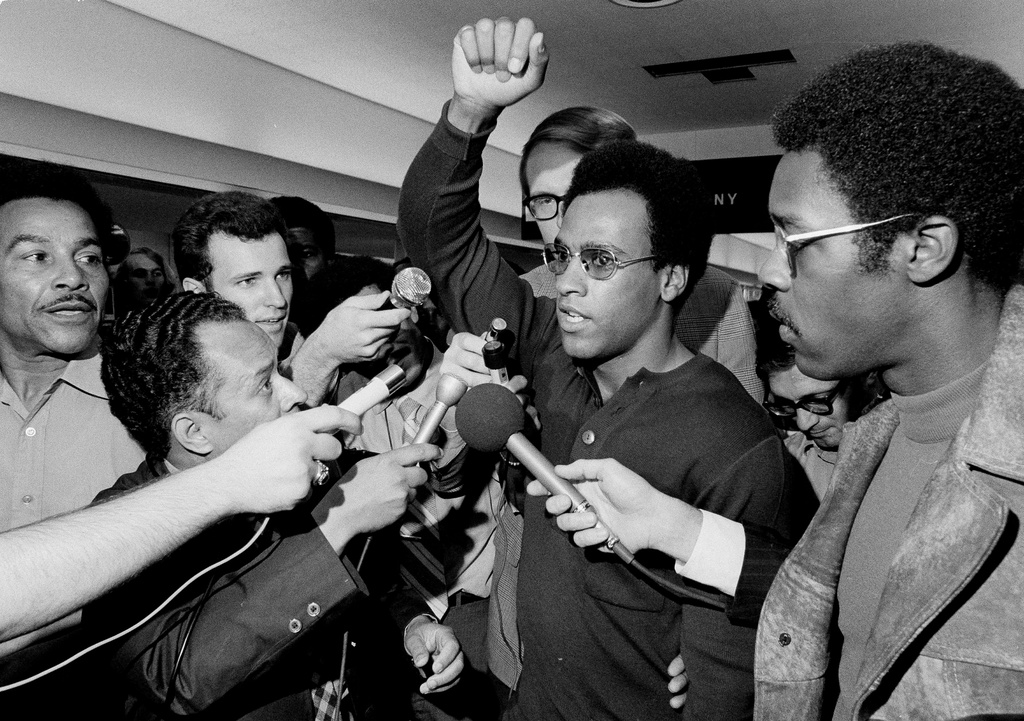 FILE - Huey Newton, Black Panther Party minister of defense, raises his arm as he is surrounded by the press at Philadelphia's International Airport, Sept. 4, 1970, upon his arrival for a convention in Philadelphia. (AP Photo/Rusty Kennedy, File)