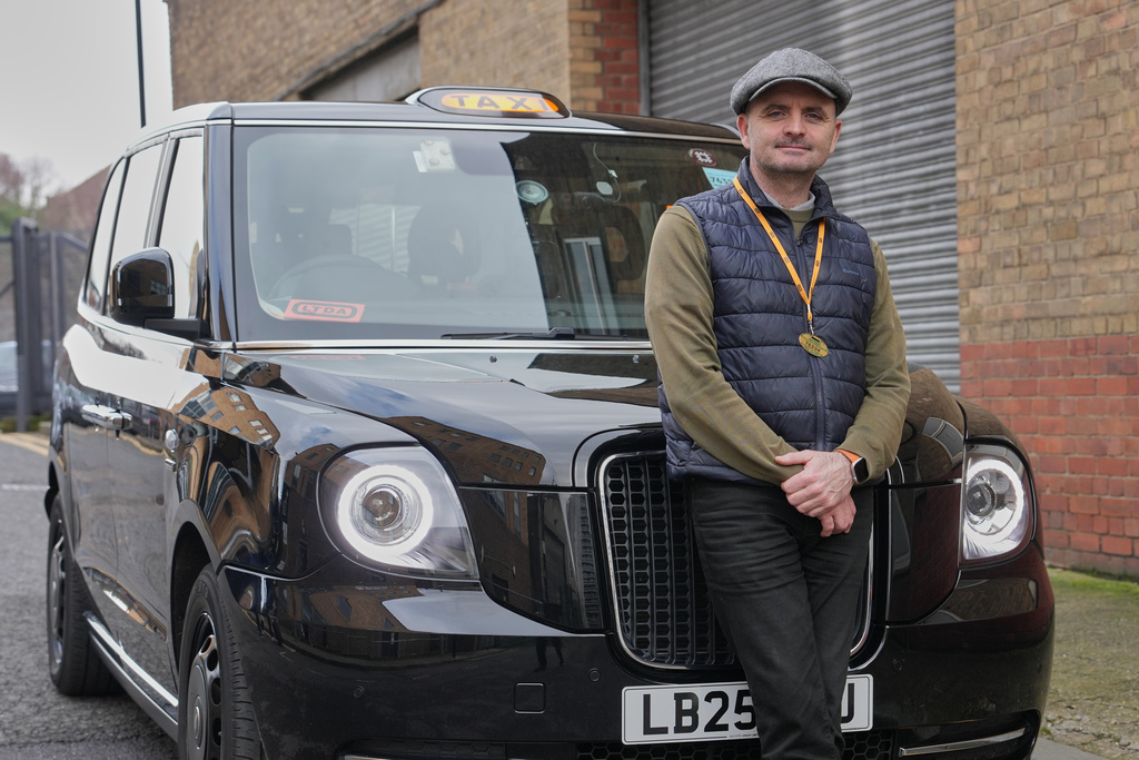Britain Robotaxis Frank O'Beirne, black cab driver poses with his taxi in London, Monday, Feb. 9, 2026. (AP Photo/Kin Cheung)